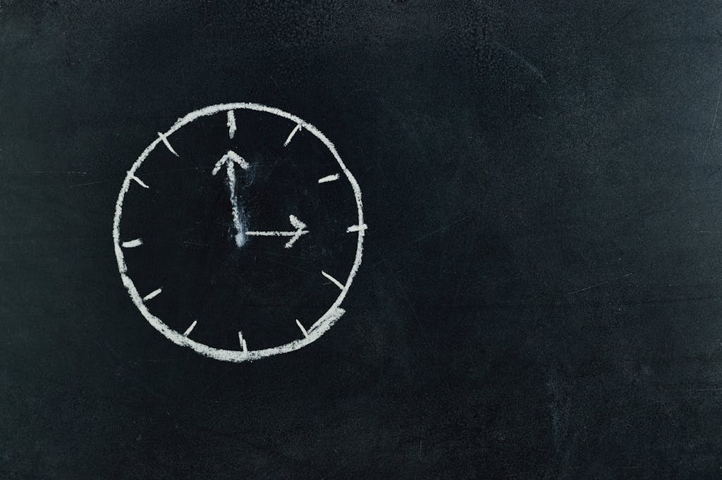 Chalk-drawn clock on a blackboard, symbolizing time and education concepts.